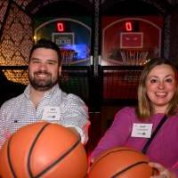 Two alumni playing basketball together at the arcade.